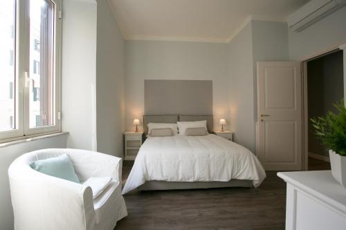 a white bedroom with a bed and a white chair at Cola Di Rienzo A E B in Rome