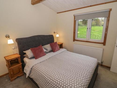 a bedroom with a bed and a window at Oak Lodge in Rugeley