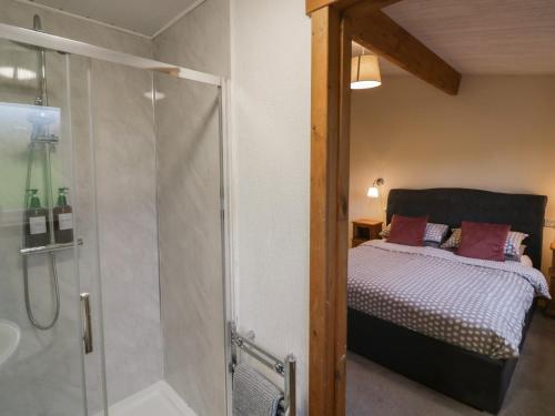 a bedroom with a bed and a glass shower at Oak Lodge in Rugeley