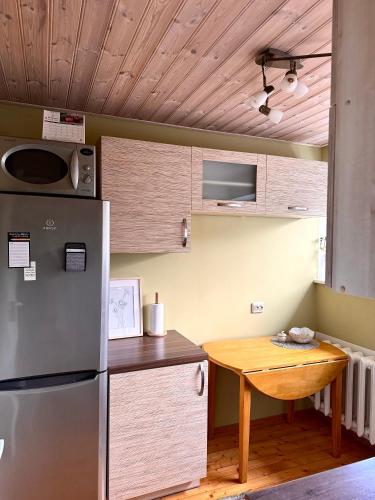 een keuken met een koelkast en een houten tafel bij Külaliskorter in Padise