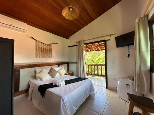 a bedroom with a bed and a large window at Pousada Mandalla in Serra do Cipo