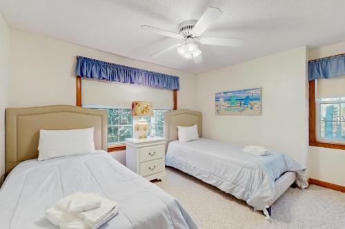 una camera da letto con due letti e un ventilatore a soffitto di Sandbar Hideaway a Old Silver Beach