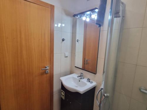 Un baño con lavabo, ducha y espejo. en Apto Vista Baía Machico, en Machico