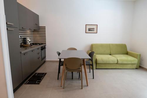 una cucina con tavolo, sedie e un divano di Marusu Apartments a Terrasini
