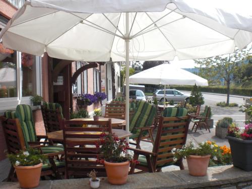 an outdoor cafe with chairs and tables and umbrellas at Alb Hotel Schalksburg in Albstadt