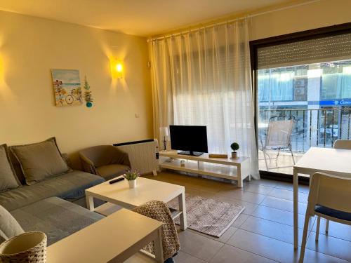 a living room with a couch and a tv at Estartit Jardins del mar 51 in L'Estartit