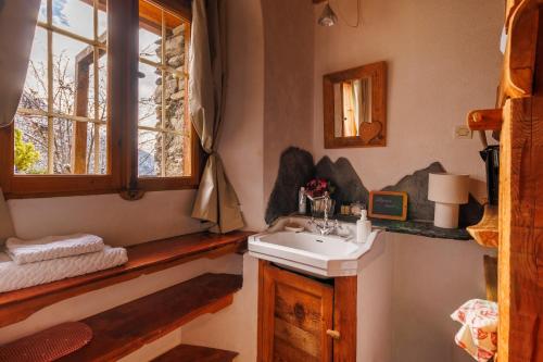 Un baño con lavabo y ventana. en La Ferme d'Angele, en Bourg-Saint-Maurice