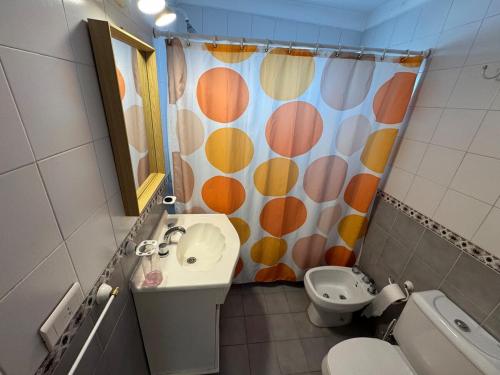 a bathroom with a sink and a toilet and a shower curtain at Tigre Centro A - piscina y seguridad 24hs - Opcional cochera paga in Tigre