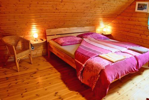 ein Schlafzimmer mit einem Bett und einem Stuhl in einem Zimmer in der Unterkunft Feriendorf Blauvogel Blauvogel 052 in Hasselfelde