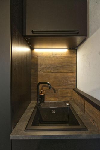 a sink in a kitchen with a light above it at Ateliéry Nad Závozom in Hrušov