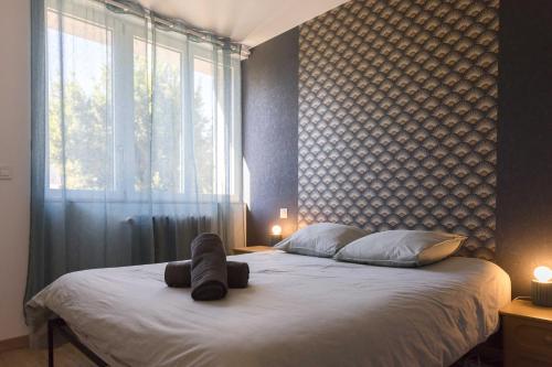 a bedroom with a large bed with a large window at Urban Nest Vitré in Vitré
