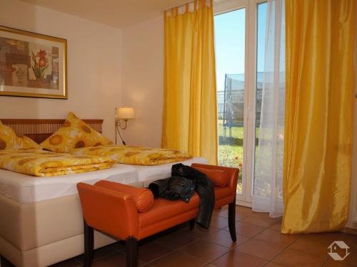 a bedroom with a bed and a chair and a window at Ferienwohnung Koch Thurgauer Weg in Reichenau