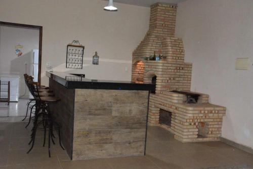 een bakstenen open haard in een woonkamer met een bar bij Sitio Belo Vale in Juiz de Fora