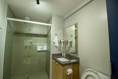 Un baño con ducha, lavabo e inodoro. en Novo studio sofisticado ao lado do Allianz Parque, en São Paulo