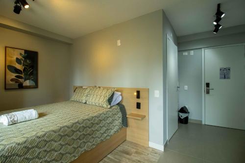 Un dormitorio con una cama y un vestidor. en Novo studio sofisticado ao lado do Allianz Parque, en São Paulo