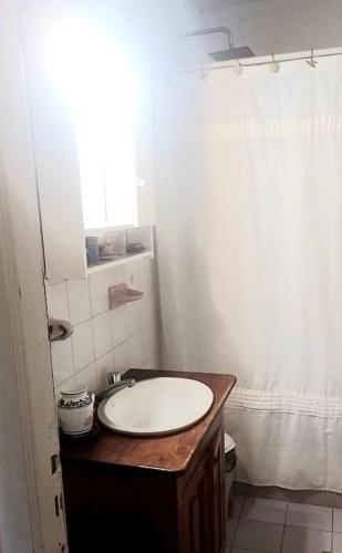 a bathroom with a white sink and a window at Tierra De Artes, casaquinta in Vuelta de Obligado
