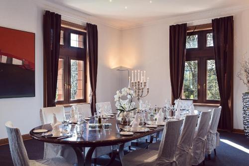una sala da pranzo con un lungo tavolo e sedie di Schlosshotel Rettershof a Kelkheim