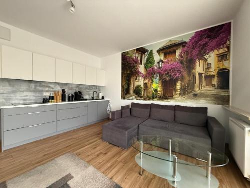 Una sala de estar con un sofá y una cocina. en Modlinska Residence by JumpInHere, en Nowy Dwór Mazowiecki