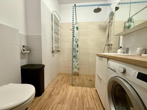 Un baño con inodoro y lavadora. en Modlinska Residence by JumpInHere, en Nowy Dwór Mazowiecki