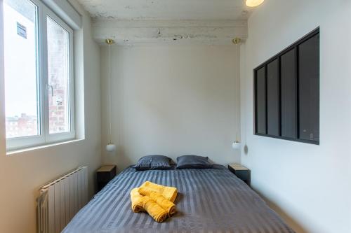 1 dormitorio con 1 cama con 2 sábanas amarillas en Loft Urban Chic - Beffroi d'Amiens, en Amiens