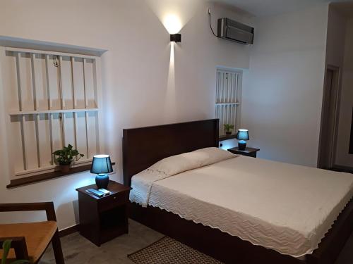 a bedroom with a bed and two lamps on tables at Coastal Residence in Hikkaduwa