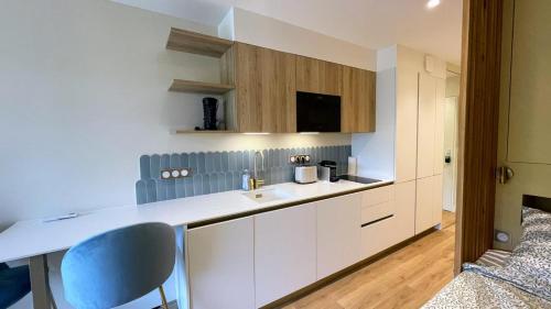 a kitchen with white cabinets and a sink at Écume et Sérénité Parking Privé Wifi Clim et LIT en 140 in La Grande-Motte