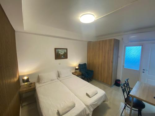 a bedroom with a white bed and a desk and a table at יחידת אירוח רחוב נחשון in Kibbutz Nachshon