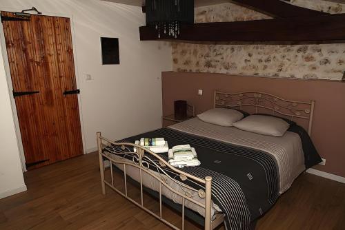 ein Schlafzimmer mit einem Bett und einem Holzboden in der Unterkunft Le Bouquet de Soizic in Grandjean