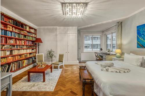a bedroom with a bed and a book shelf at The Grande Mayfair Apartment in London