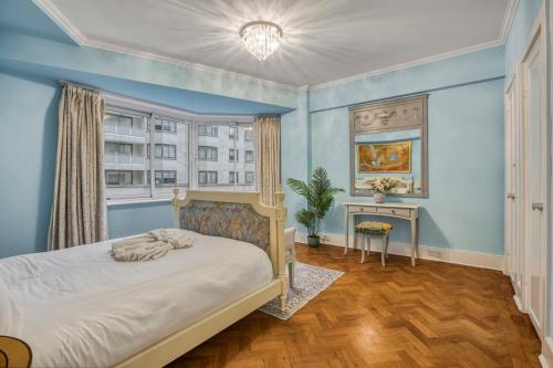 a bedroom with blue walls and a bed with a window at The Grande Mayfair Apartment in London