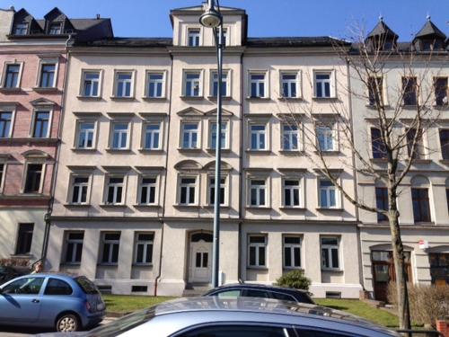 a large building with cars parked in front of it at Central Apartments Chemnitz KASSBERG in Chemnitz
