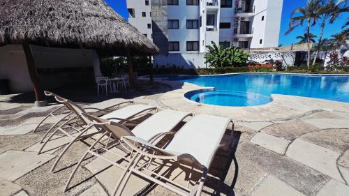 a group of lounge chairs next to a swimming pool at Familiar, amplio y con alberca in Puerto Vallarta