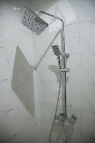 a shower with a shower head in a bathroom at Kaashmeen Hotel & Suite in Lagos