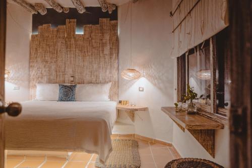 Un dormitorio con una cama grande y una mesa. en Holbox Dream Beachfront Hotel, en Isla Holbox