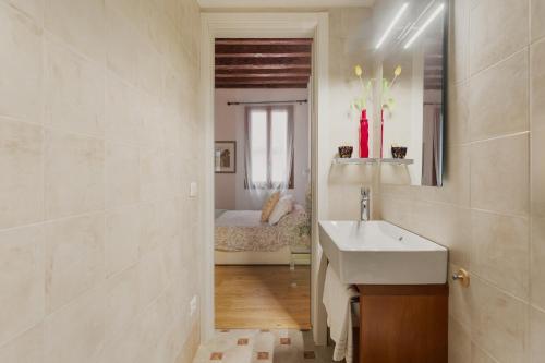 a bathroom with a sink and a bedroom with a bed at Bianca Cappello House in Venice