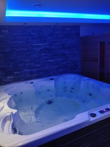 マルティーグにあるNight love jacuzzi et saunaの上部に青いライトが付いた大きな浴槽