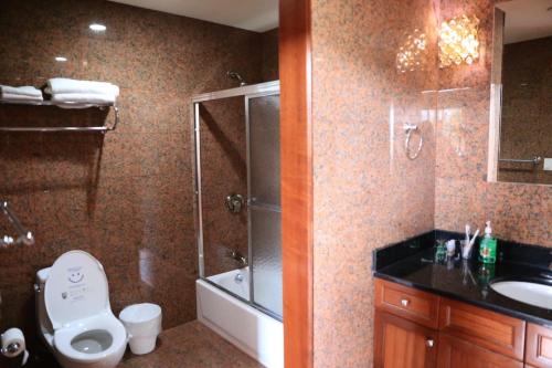 a bathroom with a shower and a toilet and a sink at Phoenix Hotel Brooklyn Sunset Park in Brooklyn