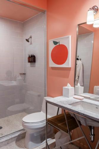 a bathroom with a toilet and a sink and a mirror at Quirk Hotel Richmond in Richmond