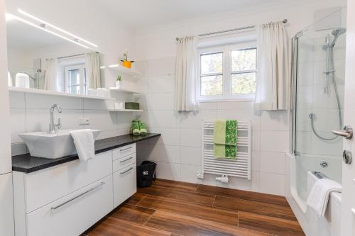 a white bathroom with a sink and a shower at Villa Eisl-Raudaschl in St. Wolfgang