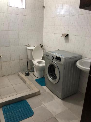 a bathroom with a washing machine and a toilet at Blue Waves Apartments in Mombasa