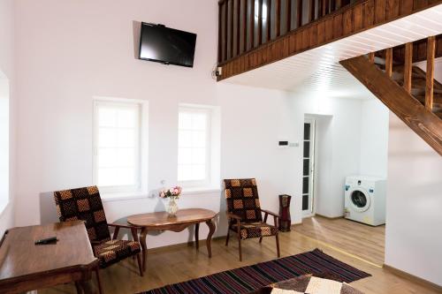 a living room with a table and chairs and a microwave at Cazare-LaBadeaMircea in Soroca
