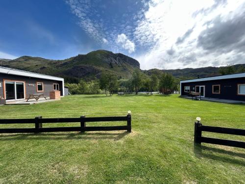 Hometainers Rio Cochrane 3 Cordon Esmeralda في كوكرين: ساحة بسياج ومبنى وجبال