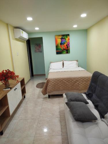 a bedroom with a bed and a couch in it at Ebratt Inn in Cartagena de Indias