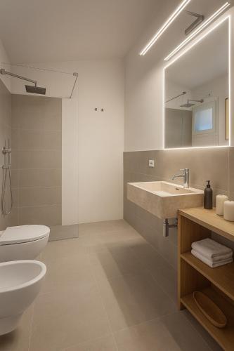 a bathroom with a sink and a toilet and a mirror at Pedra Smeralda in Golfo Aranci