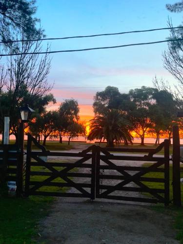 a wooden fence with a sunset in the background at El Viejo Roble in Chascomús