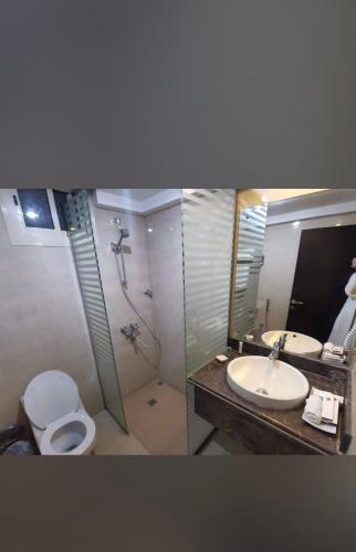 a bathroom with a shower and a toilet and a sink at Hayat Plus Hotel in Al Madinah
