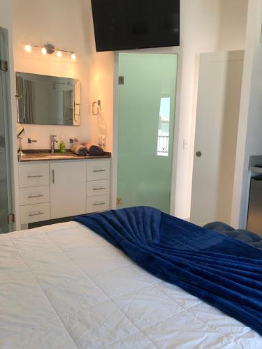 een slaapkamer met een bed met een blauwe deken erop bij Morgan Hotel Boutique & Residences, Los Cabos in Cabo San Lucas