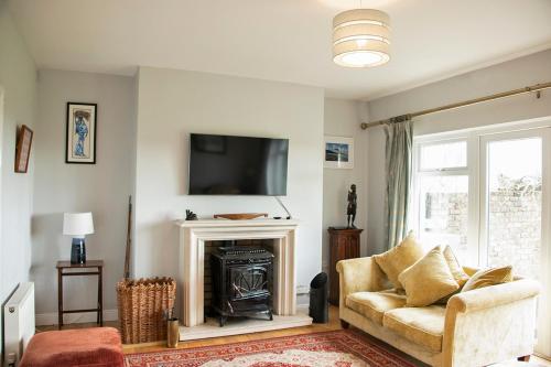 a living room with a couch and a fireplace at Loop Head Lodge Carrigaholt 4 bedroom self catering holiday home in Carrigaholt