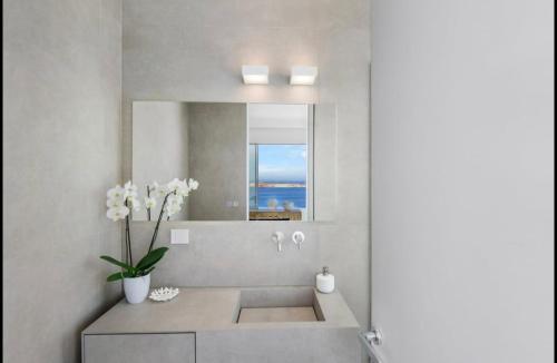 un bagno con lavandino e specchio di Endless Blue a Sarakíniko