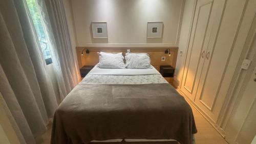 Un dormitorio con una cama grande con dos almohadas. en Flat Hotel Univer Pamplona Paulista Jardins com garagem ótima localização 1103, en São Paulo